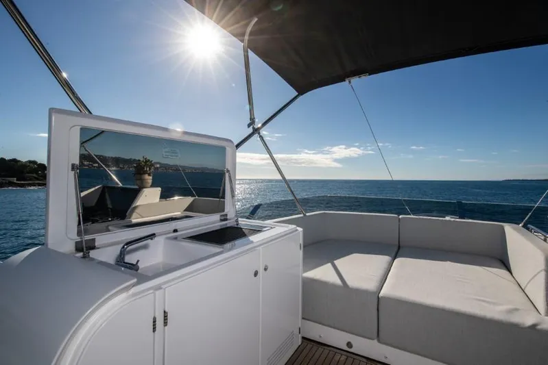  Yacht Photos Pics 2023 Azimut S8 yacht deck with seating, kitchenette, and ocean view under sunny sky.