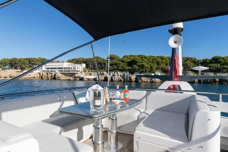  Yacht Photos Pics Luxurious 2023 Azimut S8 yacht deck with seating, table, and scenic coastal view.