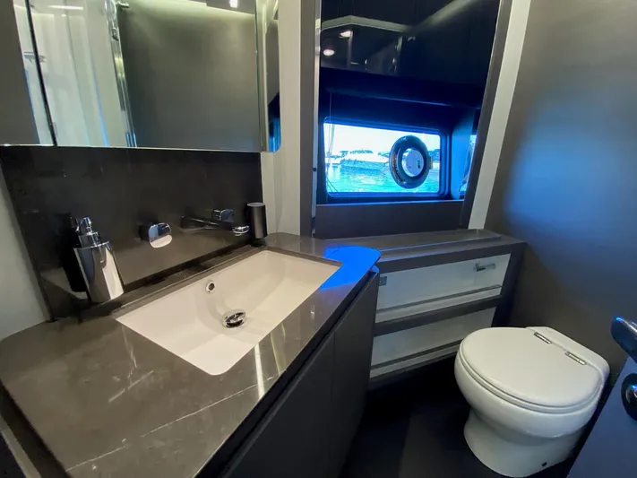  Yacht Photos Pics Luxurious bathroom in 2023 Azimut S8 yacht with modern fixtures and porthole window.