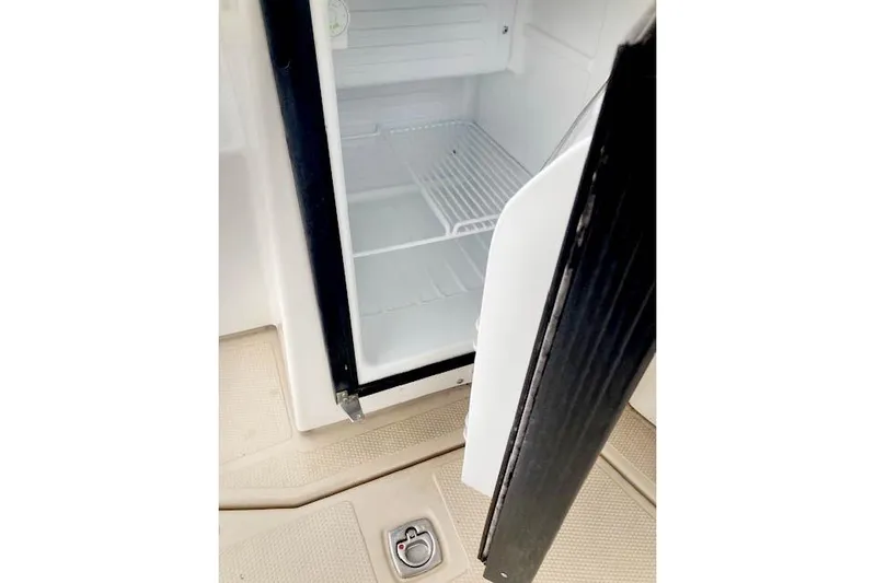 Tootles Yacht Photos Pics Open refrigerator on 2016 Ranger Tugs R-31 boat, showing empty interior and wire shelf.