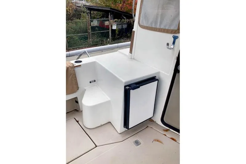 Tootles Yacht Photos Pics 2016 Ranger Tugs R-31 boat interior with compact fridge and seating area.