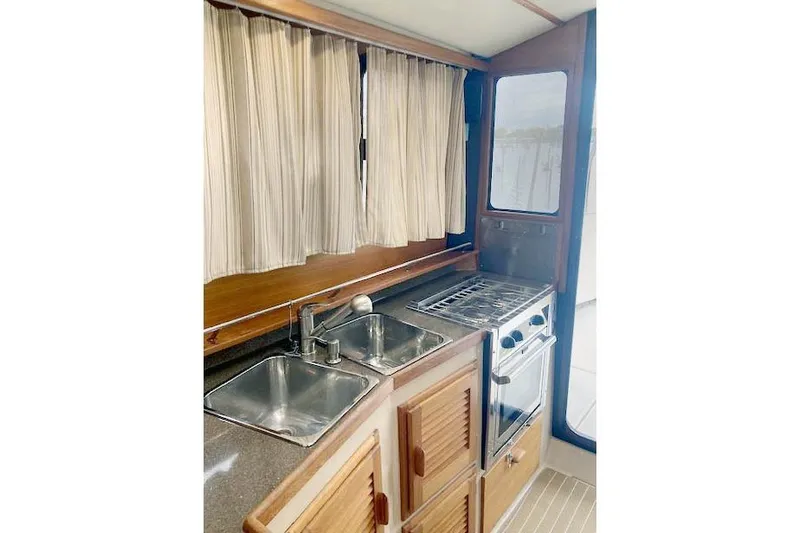 Tootles Yacht Photos Pics 2016 Ranger Tugs R-31 galley with dual sinks, stove, and wooden cabinetry.