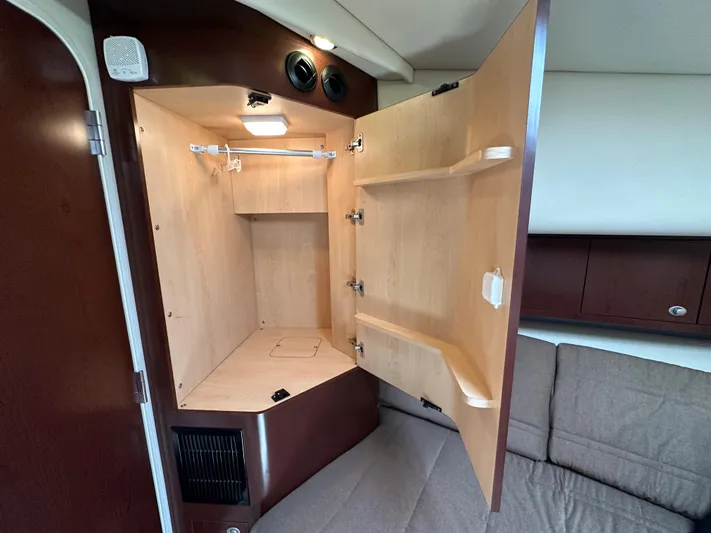 Debs Dinghy Yacht Photos Pics Open wooden cabinet inside 2007 Sea Ray 40 Motor Yacht, featuring shelves and a hanging rod.