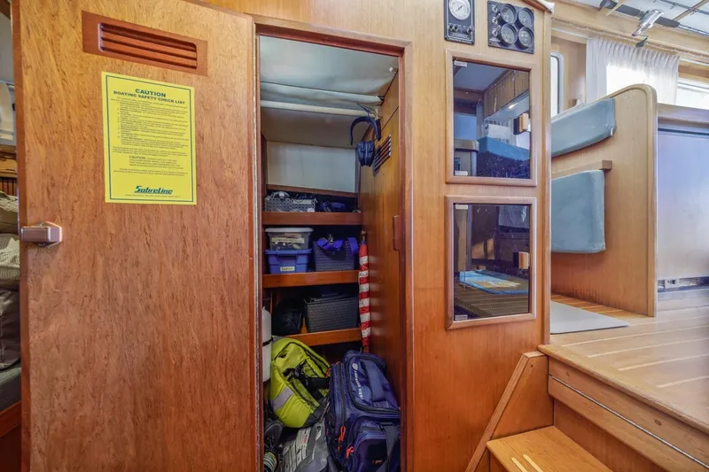 Honey Dew Yacht Photos Pics Interior storage area of 2000 Sabre 34 Flybridge boat with wooden cabinetry and safety checklist.