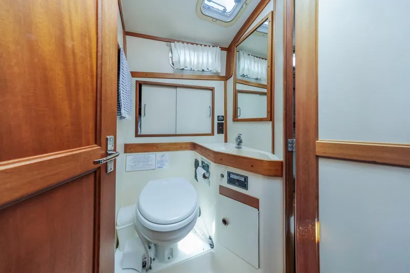 Honey Dew Yacht Photos Pics 2000 Sabre 34 Flybridge yacht bathroom with wooden accents and compact design.