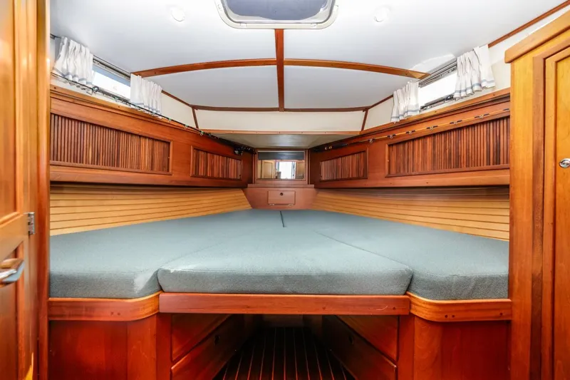 Honey Dew Yacht Photos Pics Interior cabin of 2000 Sabre 34 Flybridge with wooden finish and cozy bedding.