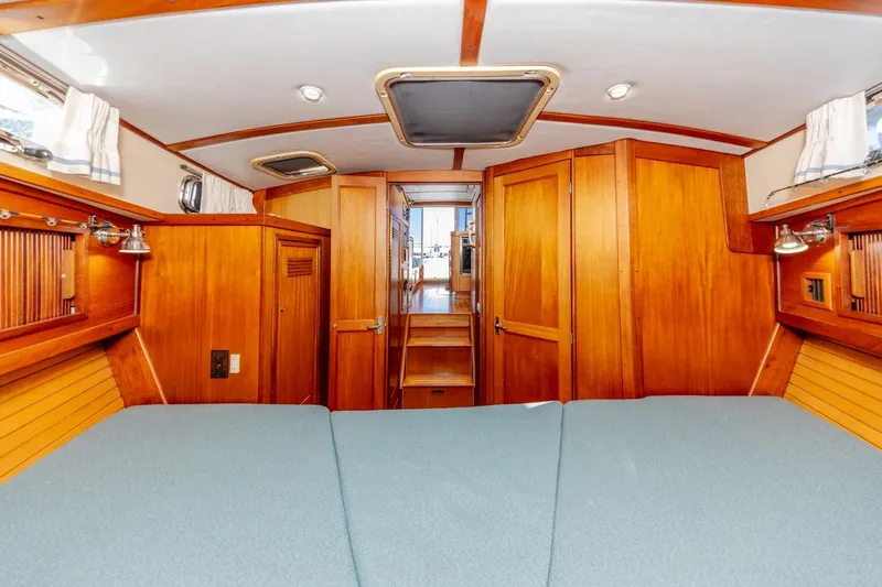 Honey Dew Yacht Photos Pics Interior of 2000 Sabre 34 Flybridge yacht with wooden cabinetry and blue bedding.