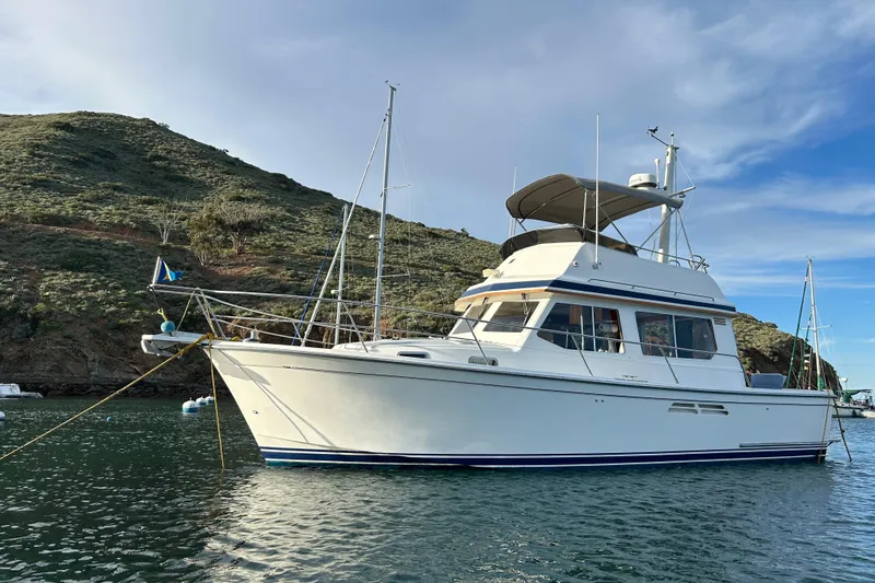 Honey Dew Yacht Photos Pics 2000 Sabre 34 Flybridge yacht anchored near a scenic hillside.