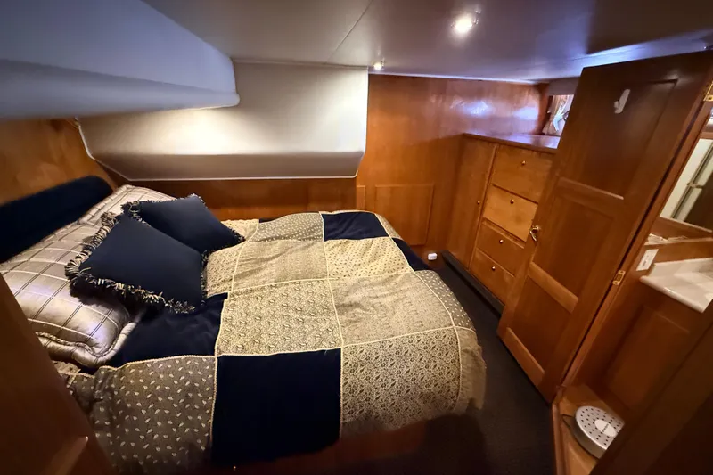 Hukilau Yacht Photos Pics Luxurious cabin interior of 2003 Navigator 4800 yacht with cozy bed and wooden furnishings.