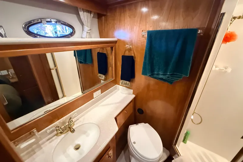 Hukilau Yacht Photos Pics Luxurious bathroom in 2003 Navigator 4800 yacht with wood accents and modern fixtures.