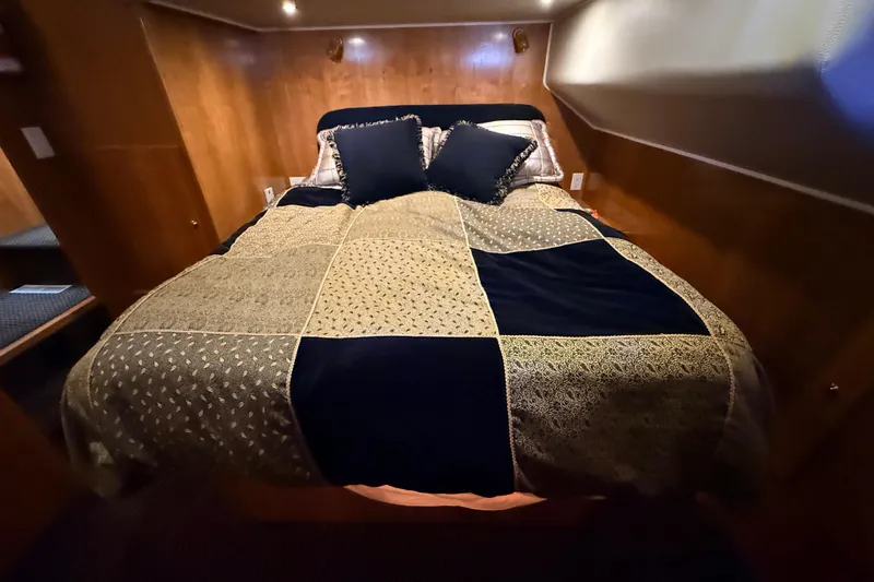 Hukilau Yacht Photos Pics Cozy bedroom in 2003 Navigator 4800 yacht with elegant bedding and wooden interior.