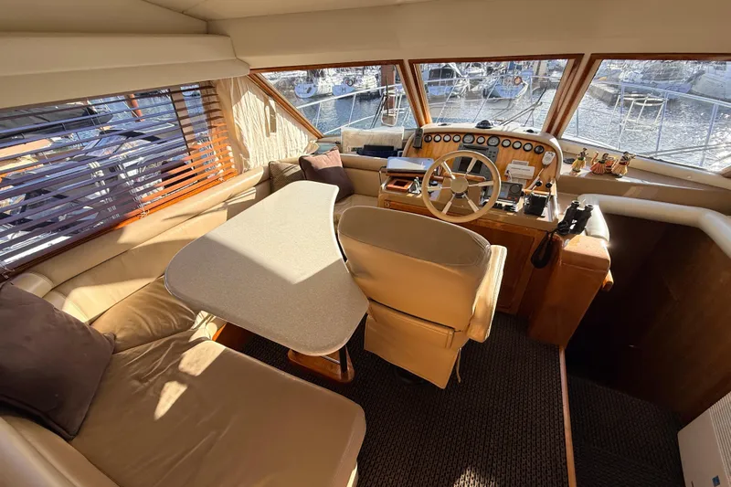 Hukilau Yacht Photos Pics 2003 Navigator 4800 yacht interior with helm, seating, and table.