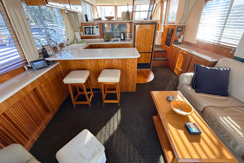 Hukilau Yacht Photos Pics Interior of 2003 Navigator 4800 yacht with wooden cabinetry and cozy seating area.