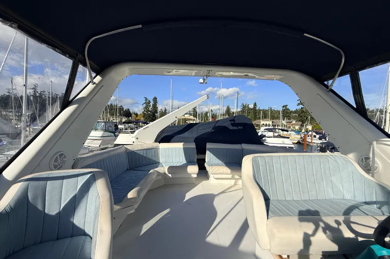 Hukilau Yacht Photos Pics Interior view of 2003 Navigator 4800 yacht with blue seating and marina backdrop.