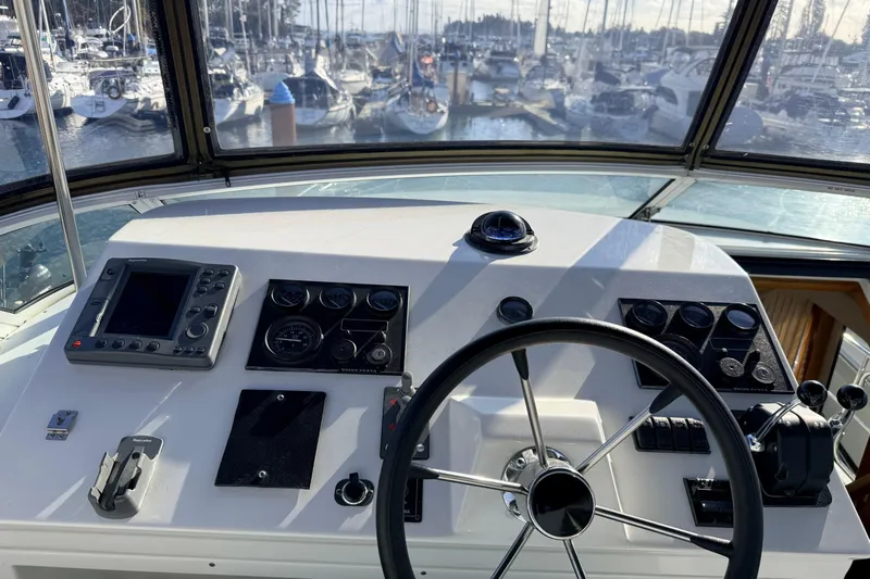 Hukilau Yacht Photos Pics 2003 Navigator 4800 yacht helm with steering wheel and navigation controls.