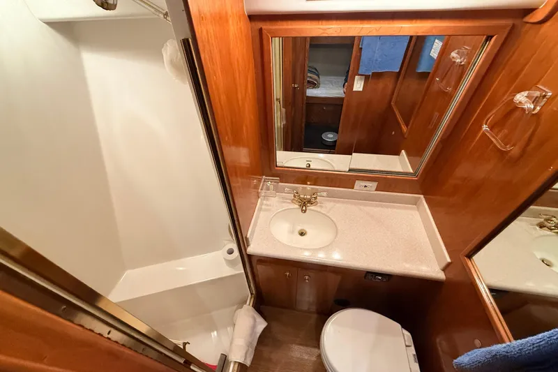 Hukilau Yacht Photos Pics Compact bathroom in 2003 Navigator 4800 yacht with sink, mirror, and shower.