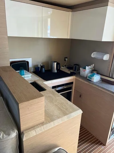 Anahita Yacht Photos Pics Compact kitchen in a 2015 Beneteau Monte Carlo 6 yacht, featuring modern appliances and sleek cabinetry.