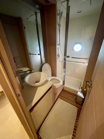 Anahita Yacht Photos Pics Bathroom interior of 2015 Beneteau Monte Carlo 6 yacht, featuring modern fixtures and porthole window.