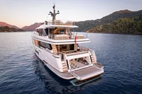 Luxurious 2023 Custom Line Navetta 30 yacht on serene water with scenic mountain backdrop.
