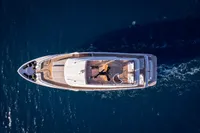 Aerial view of 2023 Custom Line Navetta 30 yacht cruising on blue ocean waters.