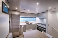 Modern kitchen interior on 2023 Custom Line Navetta 30 yacht, featuring sleek appliances and ocean view.