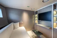 Luxurious interior of 2023 Custom Line Navetta 30 yacht with modern sofa and TV.