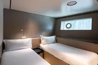 Interior of 2023 Custom Line Navetta 30 yacht with twin beds and porthole window.