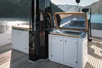 Luxurious outdoor kitchen on 2023 Custom Line Navetta 30 yacht, featuring sleek cabinetry and stunning lake view.