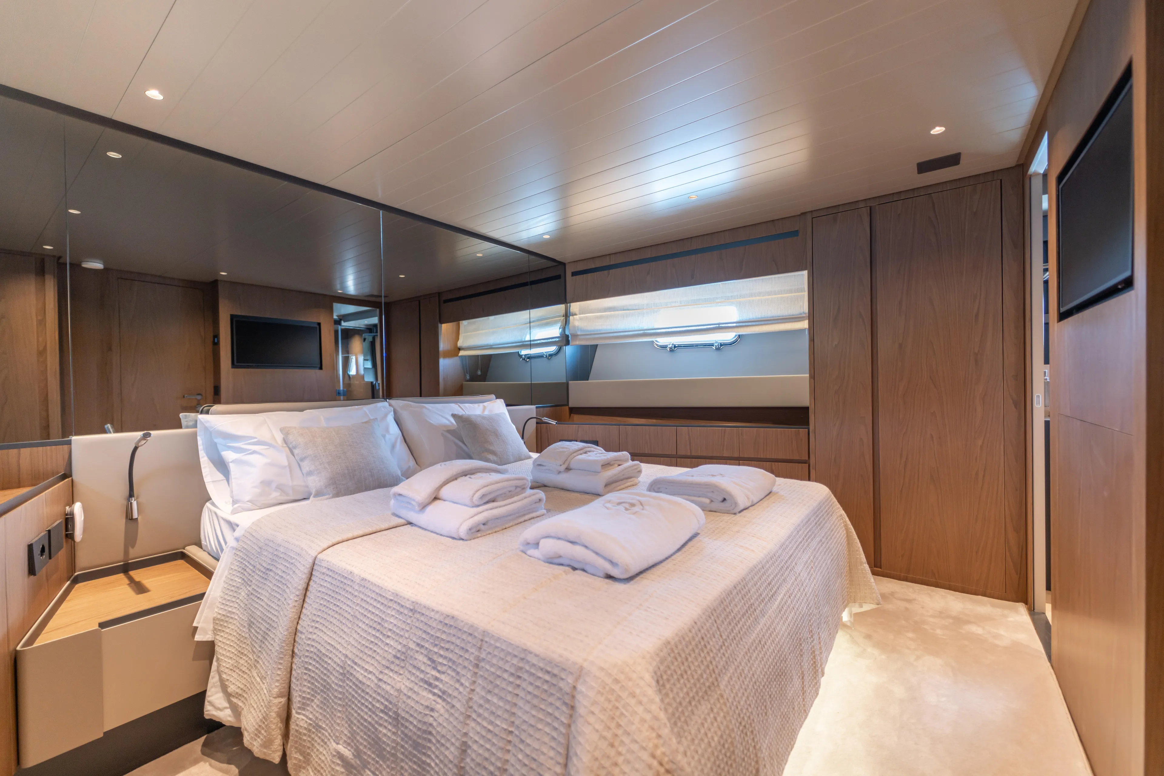  Yacht Photos Pics Luxurious bedroom interior of 2025 Bluegame BG74 yacht with elegant wood finishes.