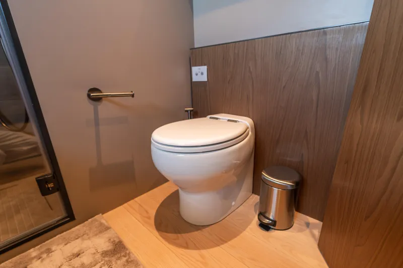  Yacht Photos Pics Modern bathroom in 2025 Bluegame BG74 yacht with sleek toilet and wood paneling.