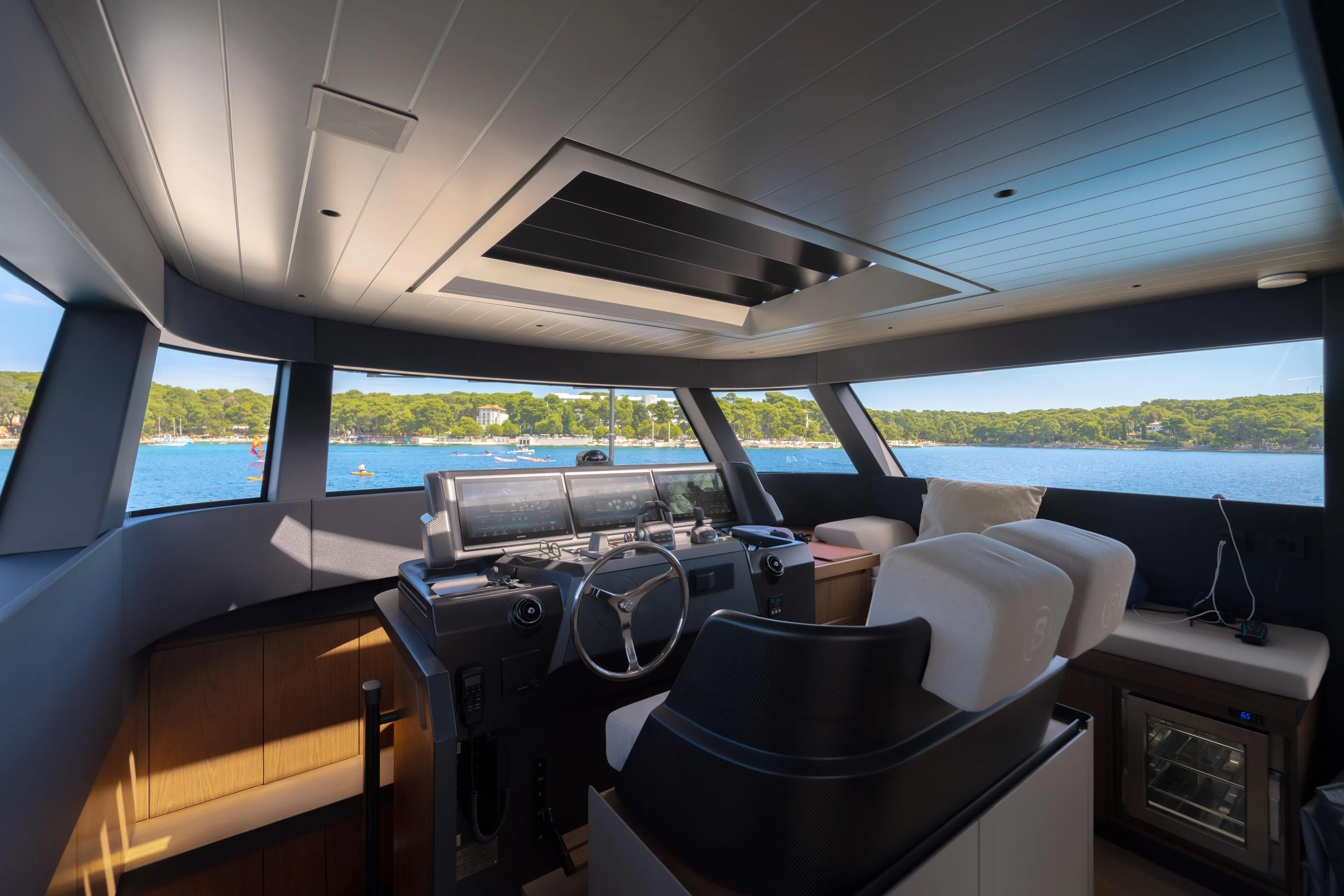  Yacht Photos Pics Interior view of 2025 Bluegame BG74 yacht cockpit with panoramic windows and modern controls.