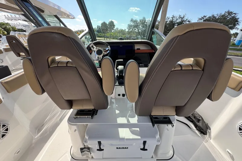  Yacht Photos Pics 2026 Monterey Elite 27 OB boat interior with dual captain seats and modern dashboard.