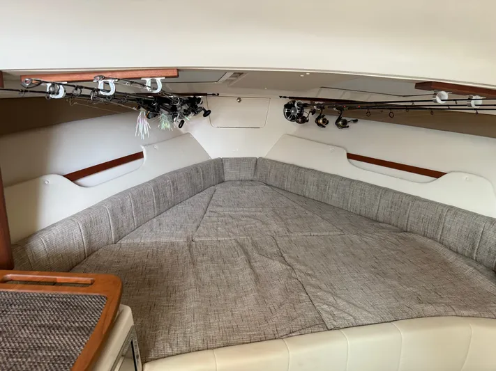  Yacht Photos Pics 2025 Grady-White Express 330 cabin interior with fishing rods and cozy seating.