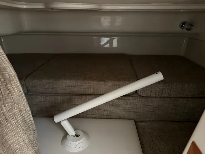  Yacht Photos Pics 2025 Grady-White Express 330 cabin interior with beige cushions and a white adjustable lamp.