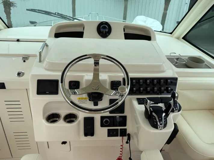  Yacht Photos Pics Helm of 2025 Grady-White Express 330 boat with steering wheel and control panel.