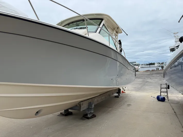  Yacht Photos Pics 2025 Grady-White Express 330 boat on dry dock, showcasing sleek design and sturdy build.