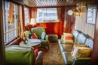 Luxurious 1982 Custom Displacement Twin Screw yacht interior with green leather seating and elegant decor.