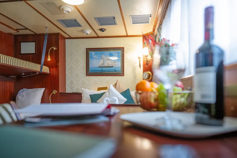 Sanssouci Star Yacht Photos Pics Luxurious yacht cabin interior with wine, fruit, and nautical decor, 1982 Custom Displacement Twin Screw.