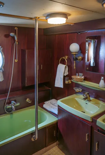 Sanssouci Star Yacht Photos Pics Vintage 1982 Custom Displacement Twin Screw yacht bathroom with green fixtures and wood paneling.