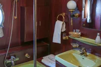 Vintage 1982 Custom Displacement Twin Screw yacht bathroom with green fixtures and wood paneling.