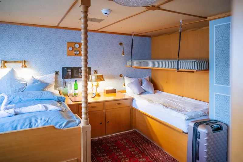 Sanssouci Star Yacht Photos Pics Cozy cabin interior with twin beds, wooden decor, and vintage accents on a 1982 Custom Displacement Twin Screw.