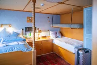 Cozy cabin interior with twin beds, wooden decor, and vintage accents on a 1982 Custom Displacement Twin Screw.