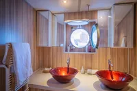 Luxurious yacht bathroom with red glass sinks and a porthole window, Custom Displacement Twin Screw, 1982.