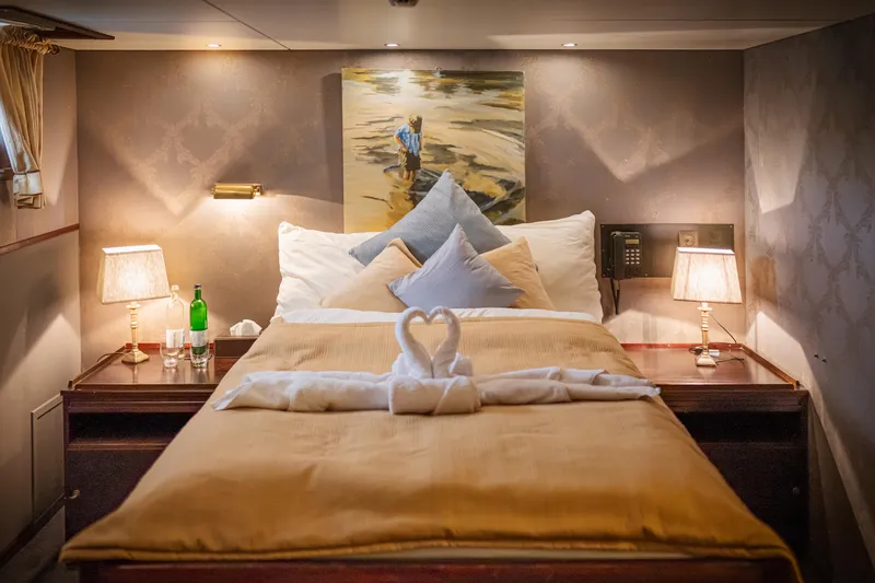 Sanssouci Star Yacht Photos Pics Luxurious cabin interior on 1982 Custom Displacement Twin Screw yacht, featuring elegant bedding and decor.