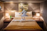 Luxurious cabin interior on 1982 Custom Displacement Twin Screw yacht, featuring elegant bedding and decor.