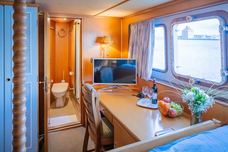 Sanssouci Star Yacht Photos Pics Luxurious cabin interior on 1982 Custom Displacement Twin Screw yacht with TV, desk, and ensuite bathroom.