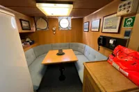 Cozy 1982 Custom Displacement Twin Screw yacht interior with dining area and nautical decor.