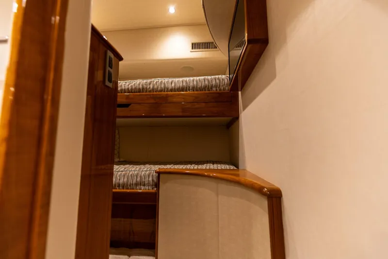Miss Virginia Yacht Photos Pics Interior of 2017 Viking 66 Convertible yacht with wooden bunk beds and soft lighting.