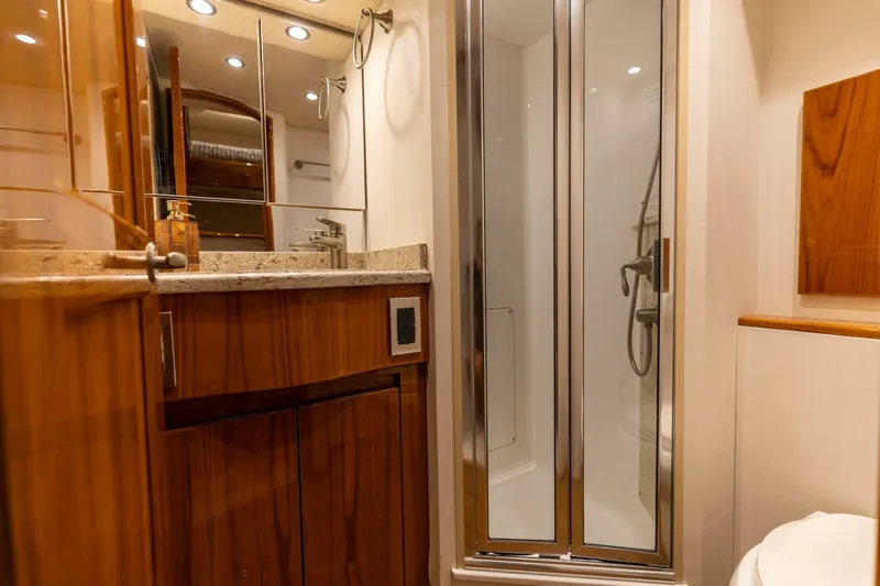Miss Virginia Yacht Photos Pics Luxurious bathroom in 2017 Viking 66 Convertible yacht with wood cabinetry and glass shower.