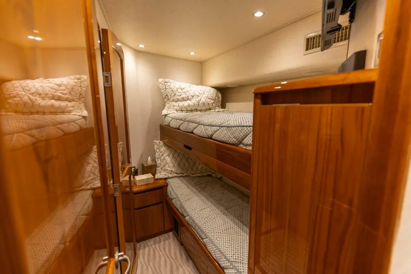 Miss Virginia Yacht Photos Pics Luxurious cabin interior of 2017 Viking 66 Convertible yacht with wooden finishes and cozy bedding.